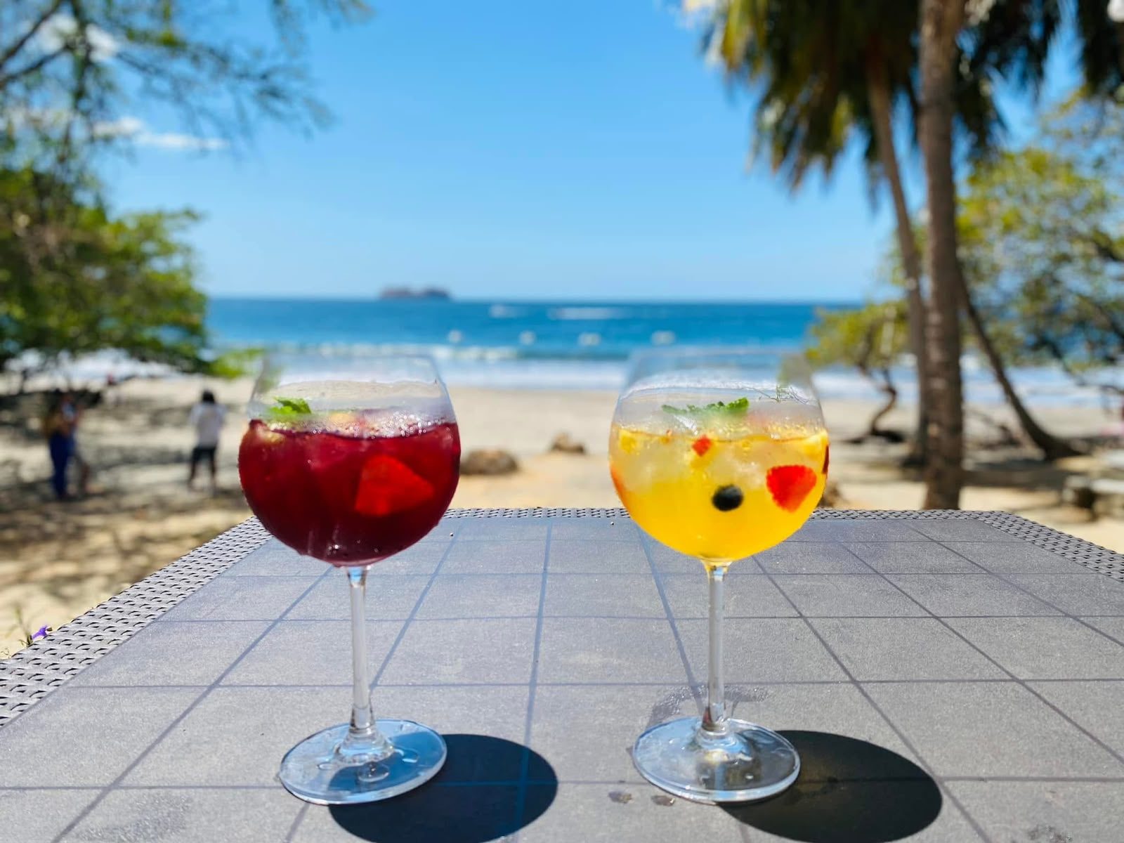 Dos copas de sangría sobre una mesa frente al mar en Playa Hermosa